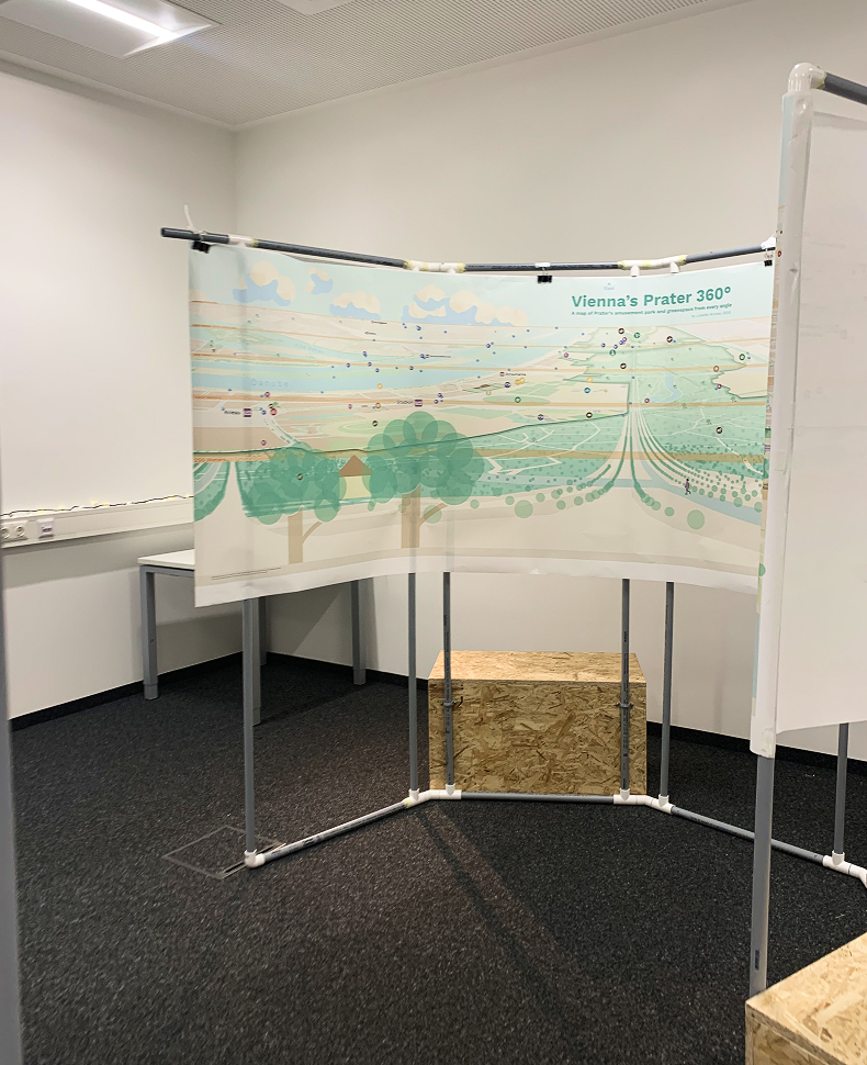 A large cylinder structure hanging a paper map along its walls